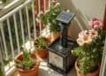 Kleiner Solarspringbrunnen auf Balkon mit Keramikschale und mediterranen Pflanzen